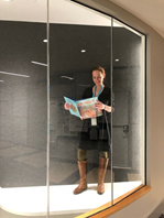 Laura C standing, reading a book